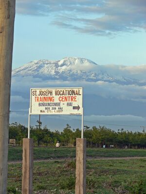 Bild vom Wegweiser zur Schule mit Kilimandscharo im Hintergrund